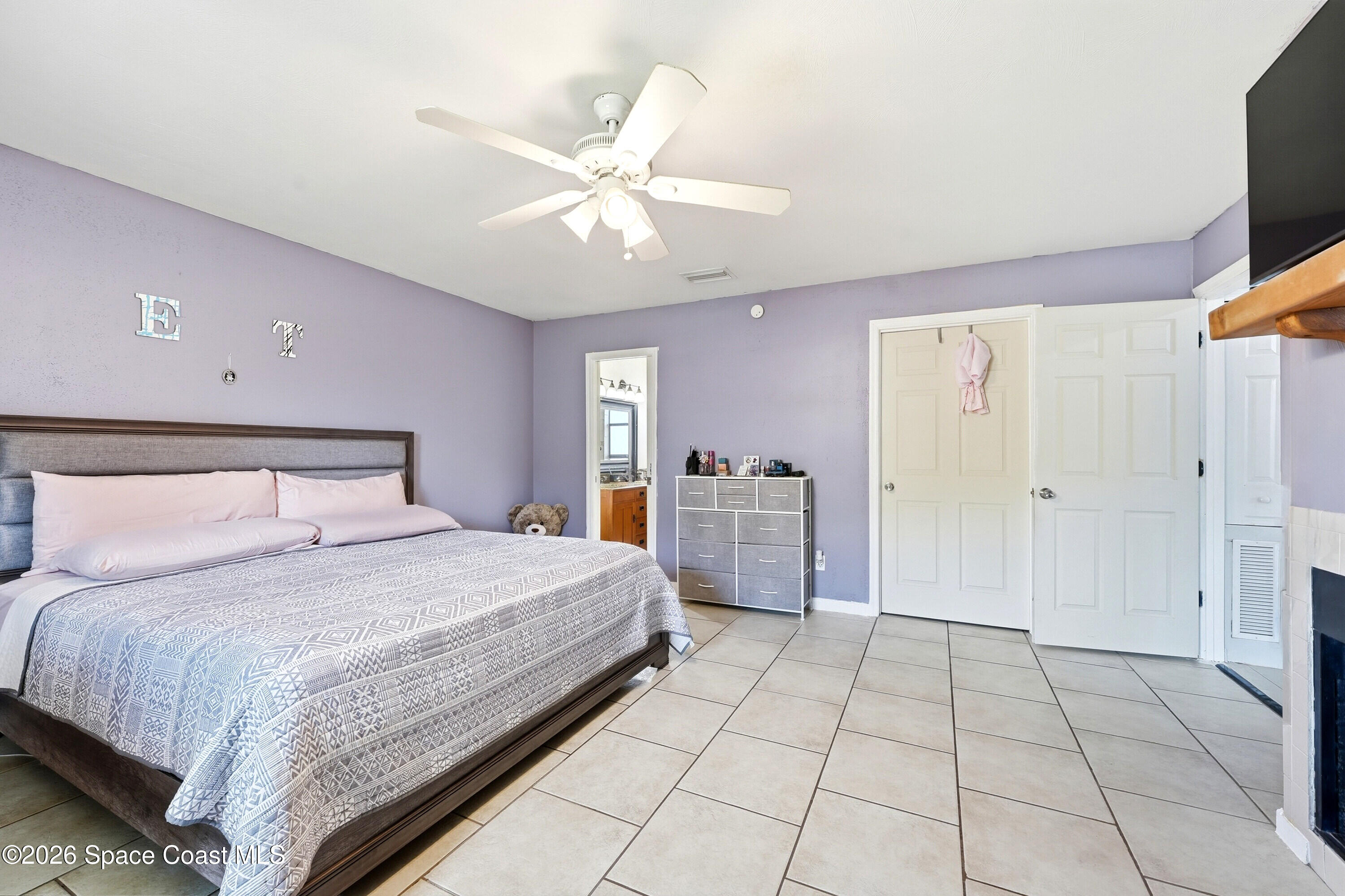 830 Garvey Road Palm Bay, FL 32908 - Photo 19 of 48 a spacious bedroom with a bed and a chandelier