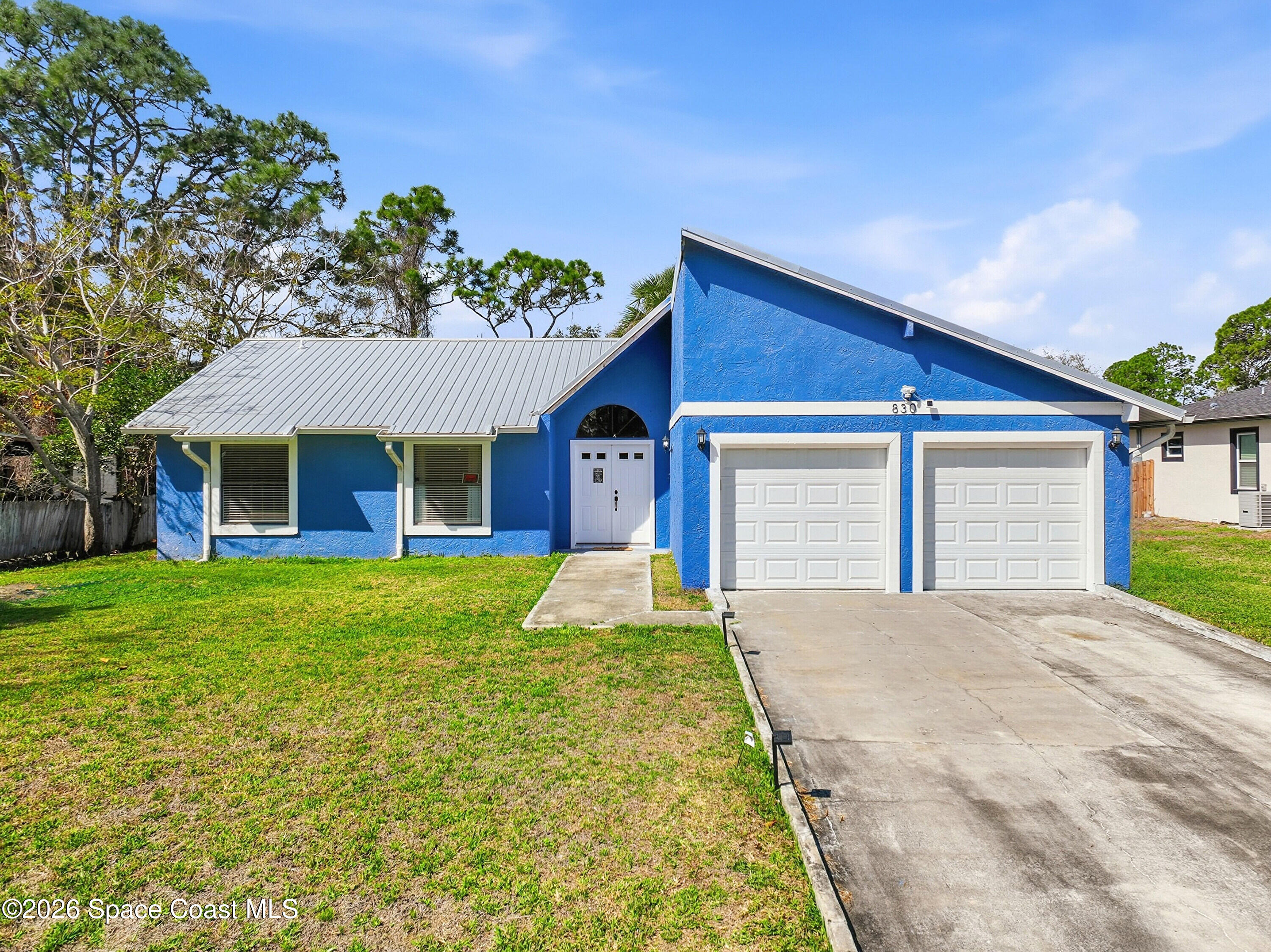 830 Garvey Road Palm Bay, FL 32908 - Photo 2 of 48 a front view of a house with a yard and garage