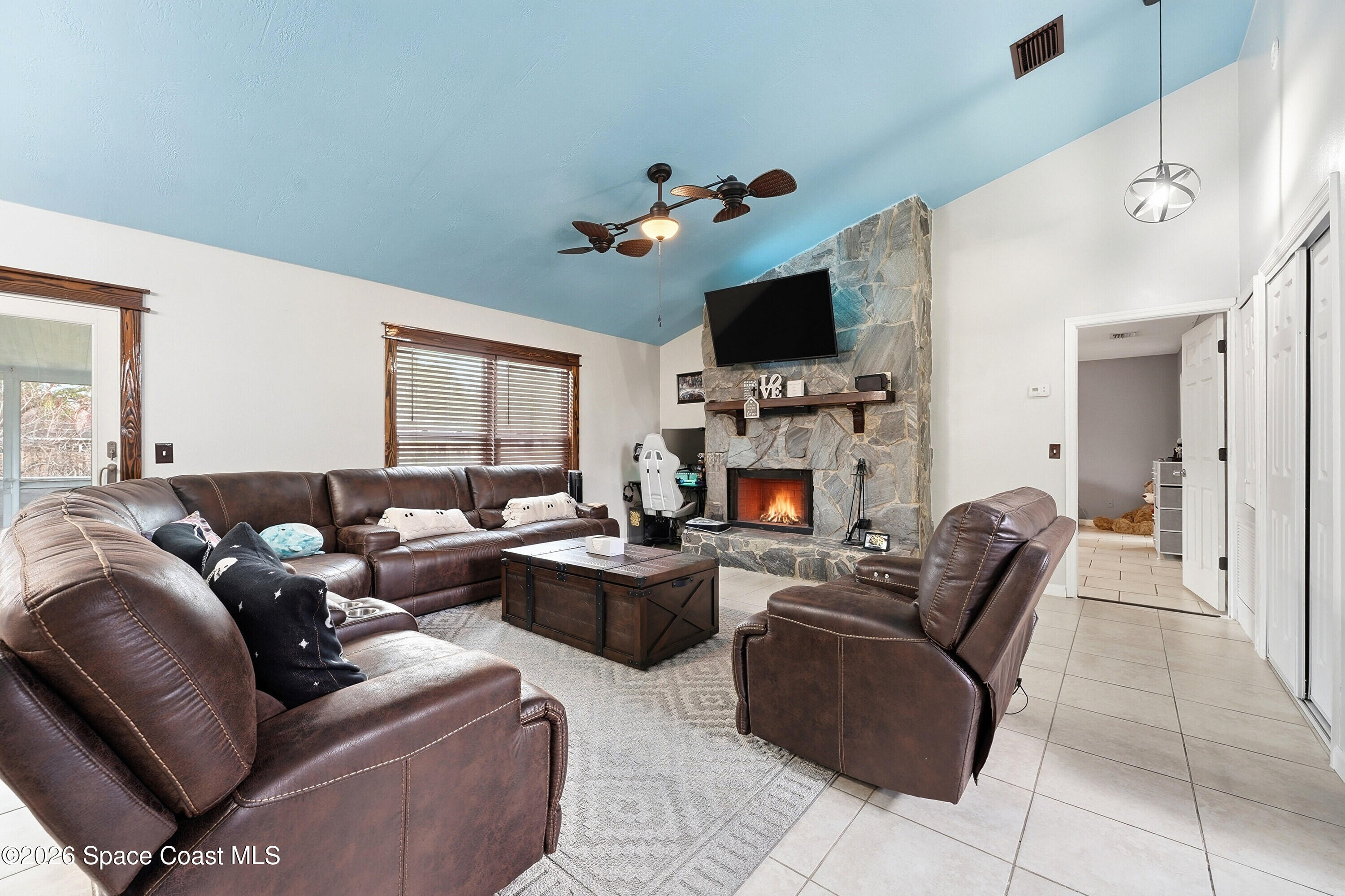 830 Garvey Road Palm Bay, FL 32908 - Photo 9 of 48 a living room with furniture a flat screen tv and a fireplace