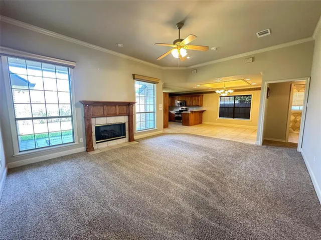 an empty room with a fireplace and chandelier
