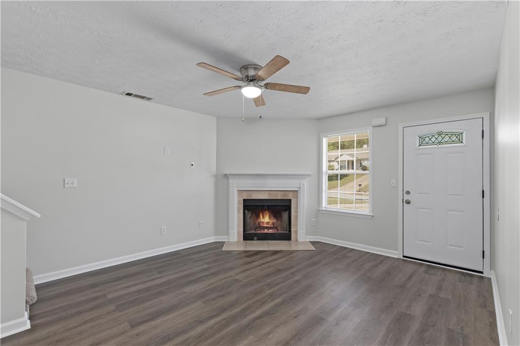 150 Fairclift Drive Covington, GA 30016 - Photo 3 of 22 a view of an empty room with wooden floor fireplace and a window