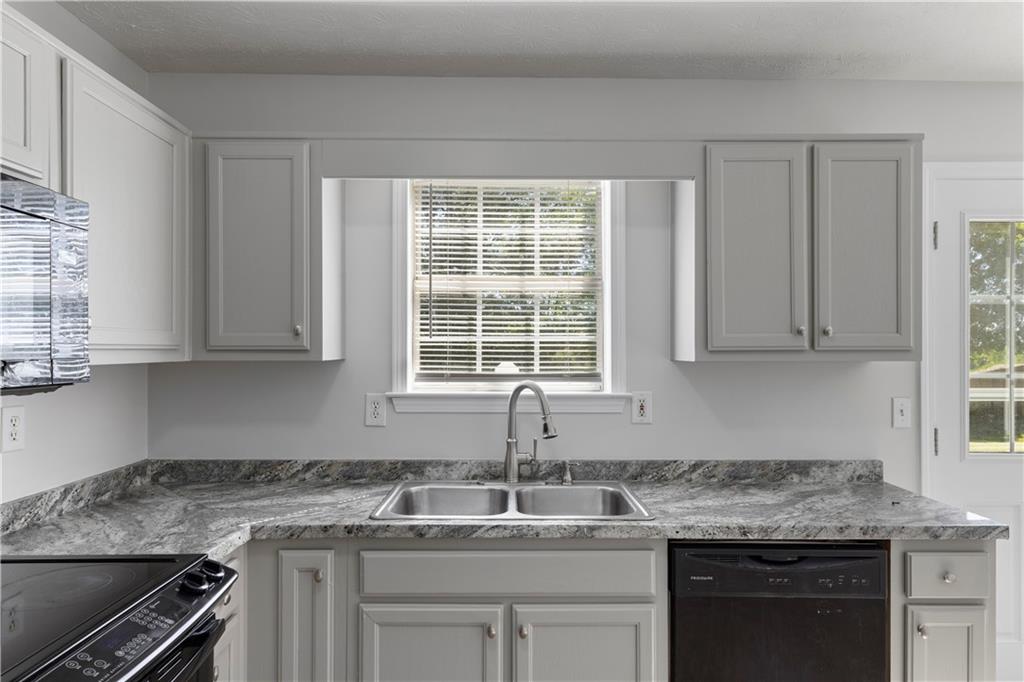 150 Fairclift Drive Covington, GA 30016 - Photo 6 of 22 a kitchen with granite countertop a sink stove and cabinets