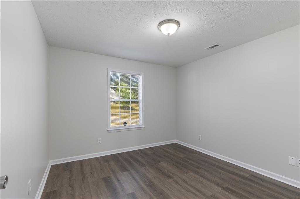 150 Fairclift Drive Covington, GA 30016 - Photo 10 of 22 an empty room with wooden floor and windows