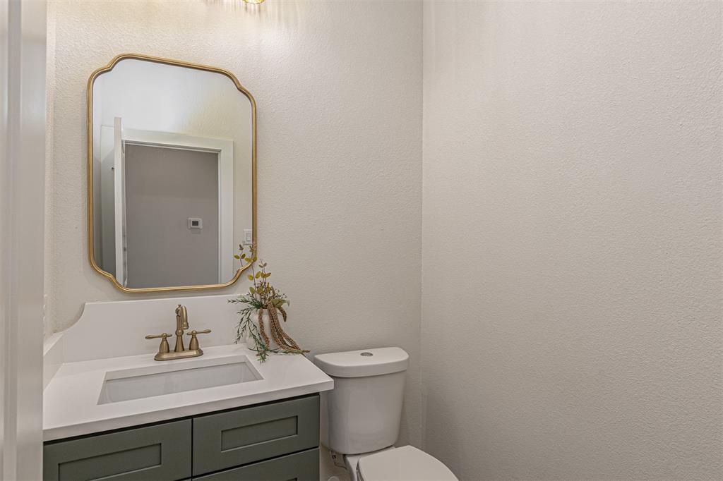 360 Dalton Road Canton, TX 75103 - Photo 13 of 33 Powder room featuring a sage green vanity with white countertop, integrated sink, and brass-finish fixtures