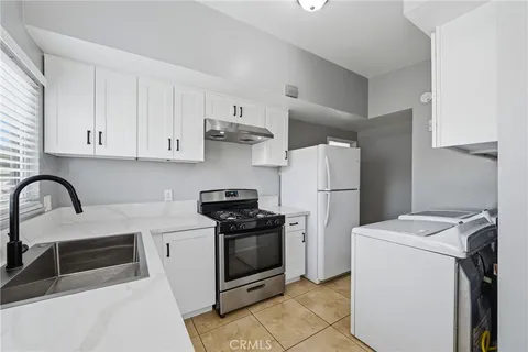 a kitchen with a stove a refrigerator and cabinets