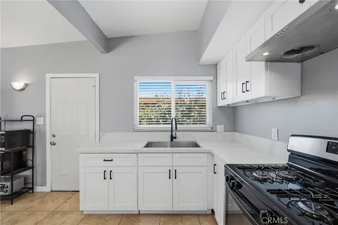 a kitchen with white cabinets and a stove top oven