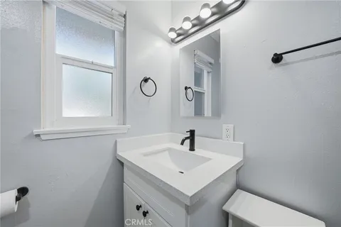 a bathroom with a sink a toilet and a mirror