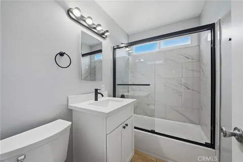 a bathroom with a shower sink vanity and mirror