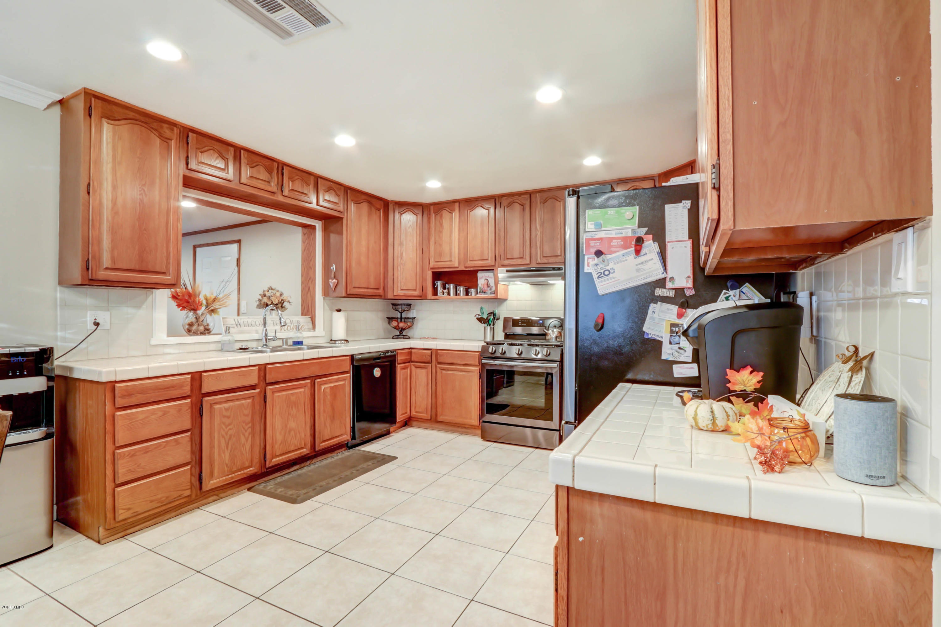 6205 Melia Street Simi Valley, CA 93063 - Photo 10 of 36 a kitchen with a sink a counter top space stainless steel appliances and cabinets