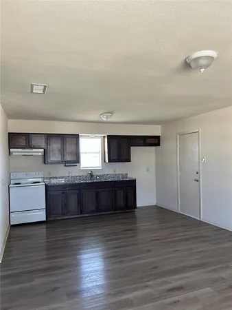 a large kitchen with a wooden floor and a sink