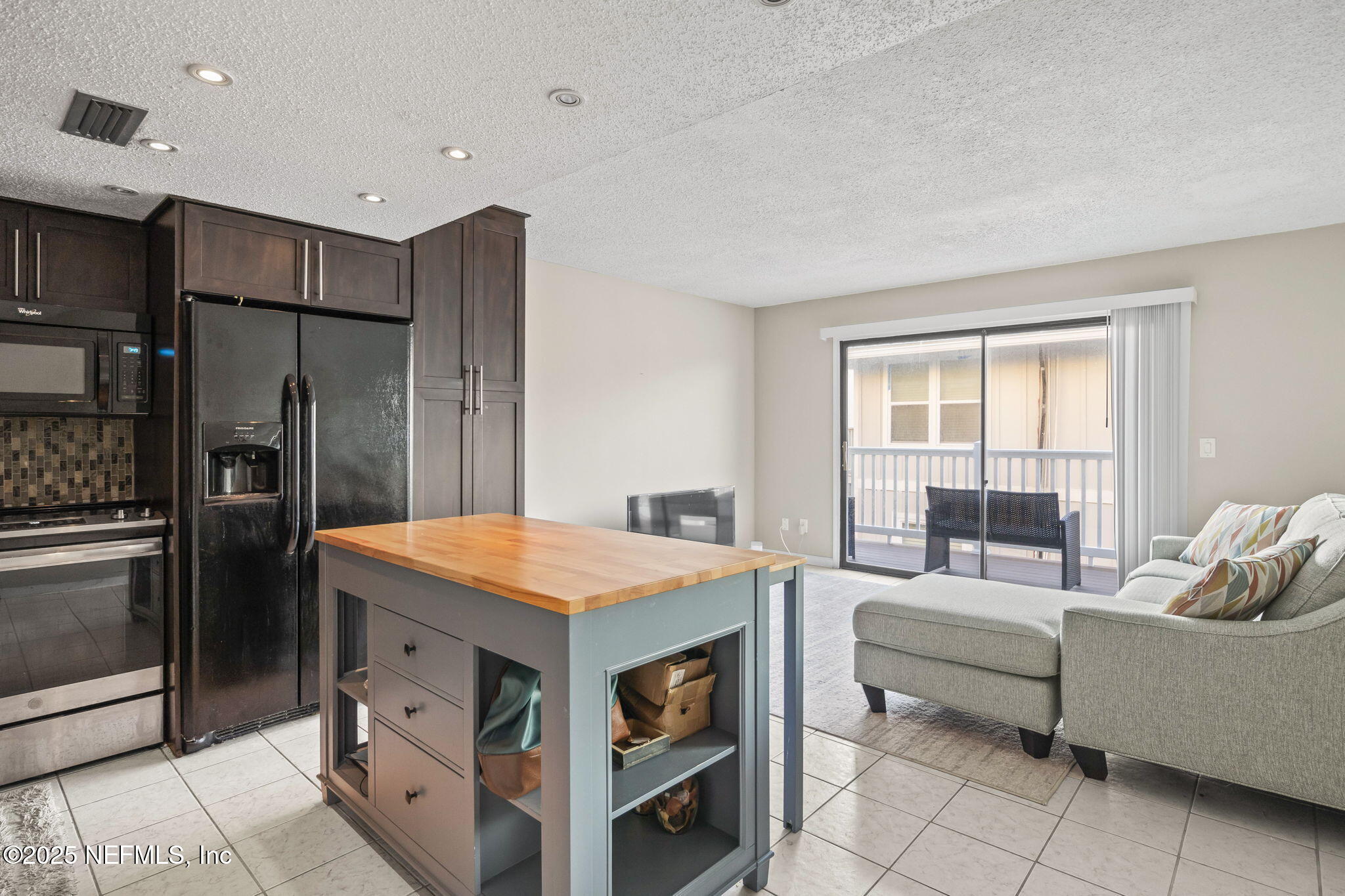 1107 1st Street South, Unit B Jacksonville Beach, FL 32250 - Photo 2 of 45 a kitchen with stainless steel appliances kitchen island granite countertop a refrigerator and a sink