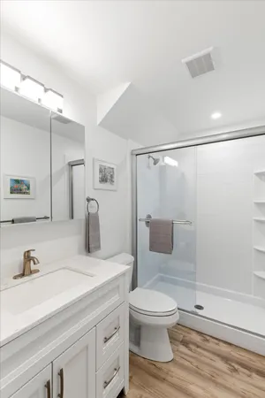 a bathroom with a sink a toilet and shower