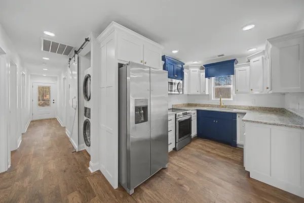 a kitchen with stainless steel appliances granite countertop a sink stove and microwave