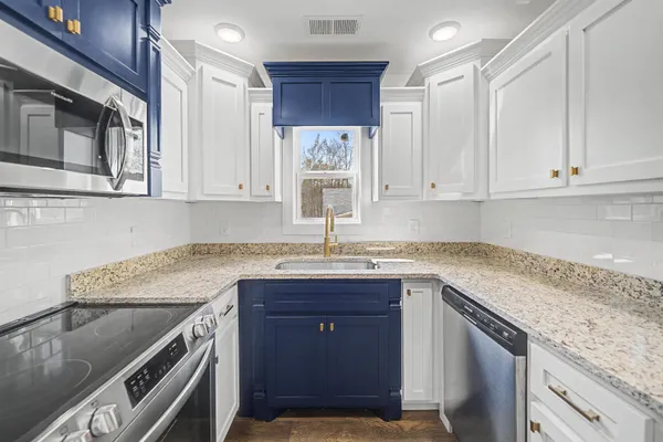 a kitchen with granite countertop cabinets sink and window