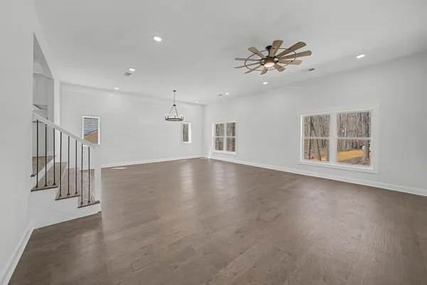 a view of a livingroom with wooden floor and staircase