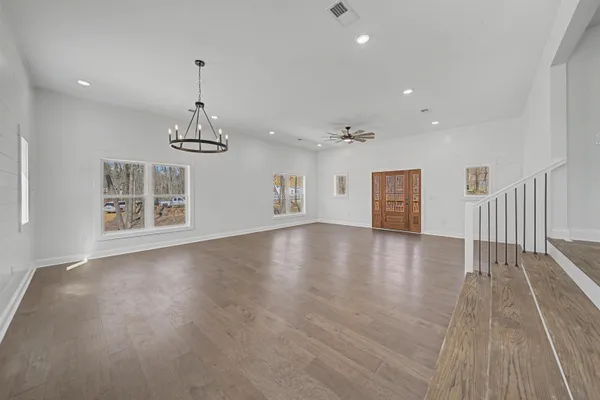 a view of a livingroom with wooden floor and a ceiling fan
