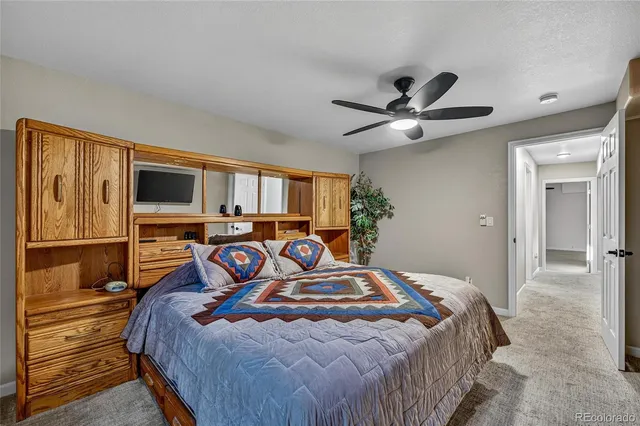 a bedroom with a bed and a flat tv screen on the dresser