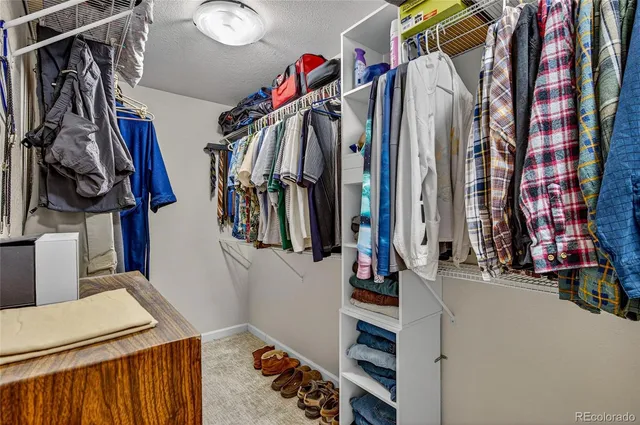 a view of walk in closet with clothes and shoes