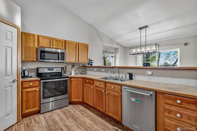 a kitchen with stainless steel appliances granite countertop a sink stove and microwave
