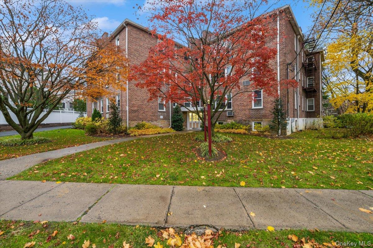 600 Pelham Road, Unit A2D New Rochelle, NY 10805 - Photo 2 of 19 View of side of property with brick siding and a lawn