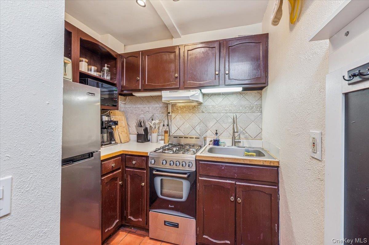 600 Pelham Road, Unit A2D New Rochelle, NY 10805 - Photo 6 of 19 Kitchen with a textured wall, tasteful backsplash, freestanding refrigerator, gas range, and light countertops