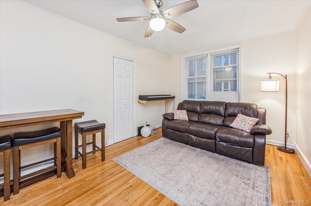600 Pelham Road, Unit A2D New Rochelle, NY 10805 - Photo 9 of 19 Living area featuring light wood-style floors, ornamental molding, and a ceiling fan