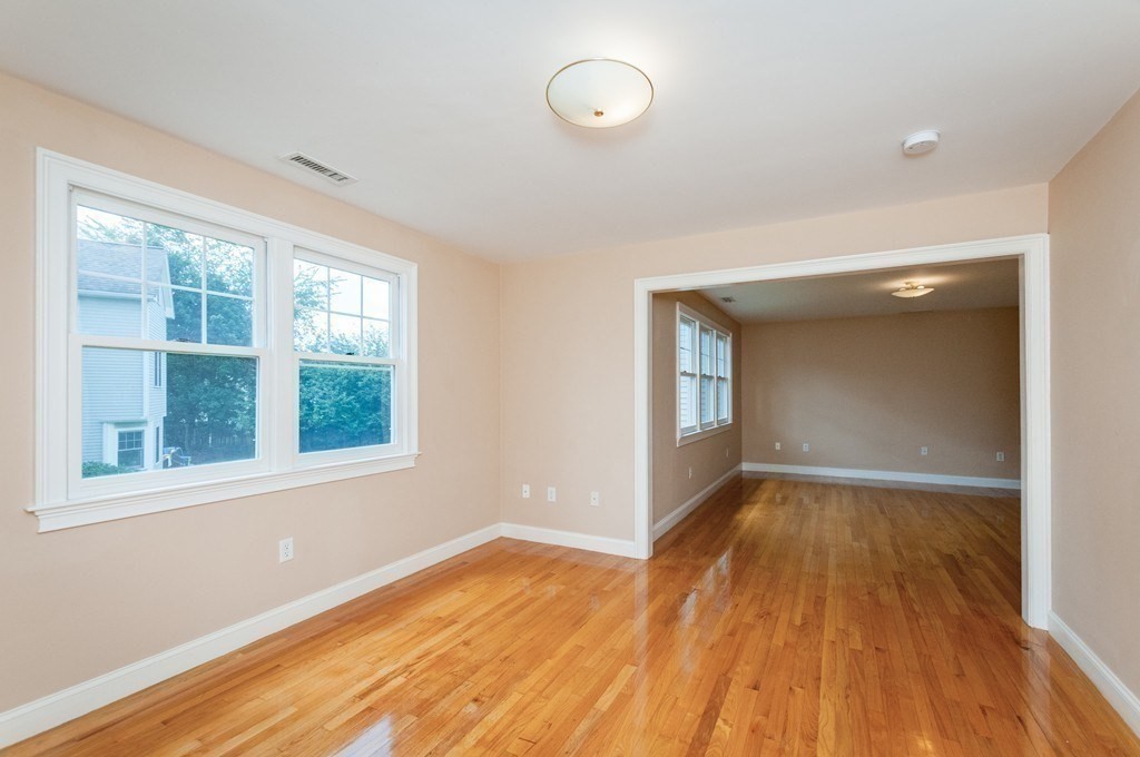 232 Pearl Street, Unit 232 Newton, MA 02458 - Photo 12 of 27 an empty room with wooden floor and windows
