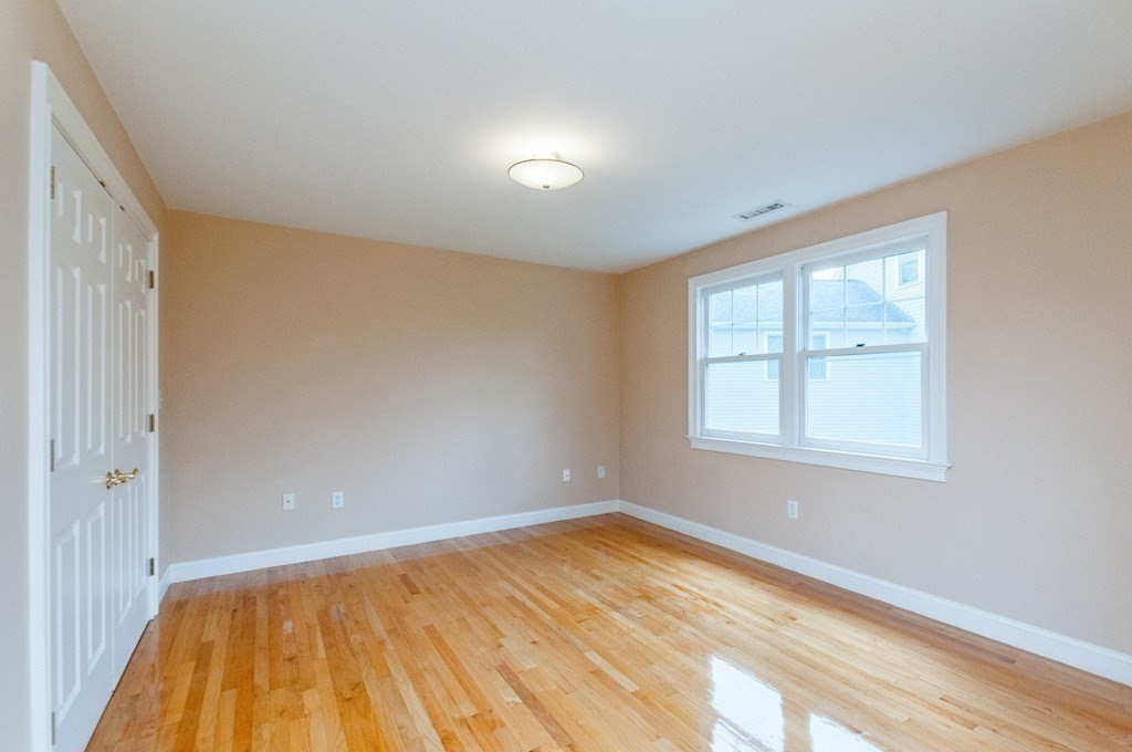 232 Pearl Street, Unit 232 Newton, MA 02458 - Photo 14 of 27 an empty room with wooden floor and windows