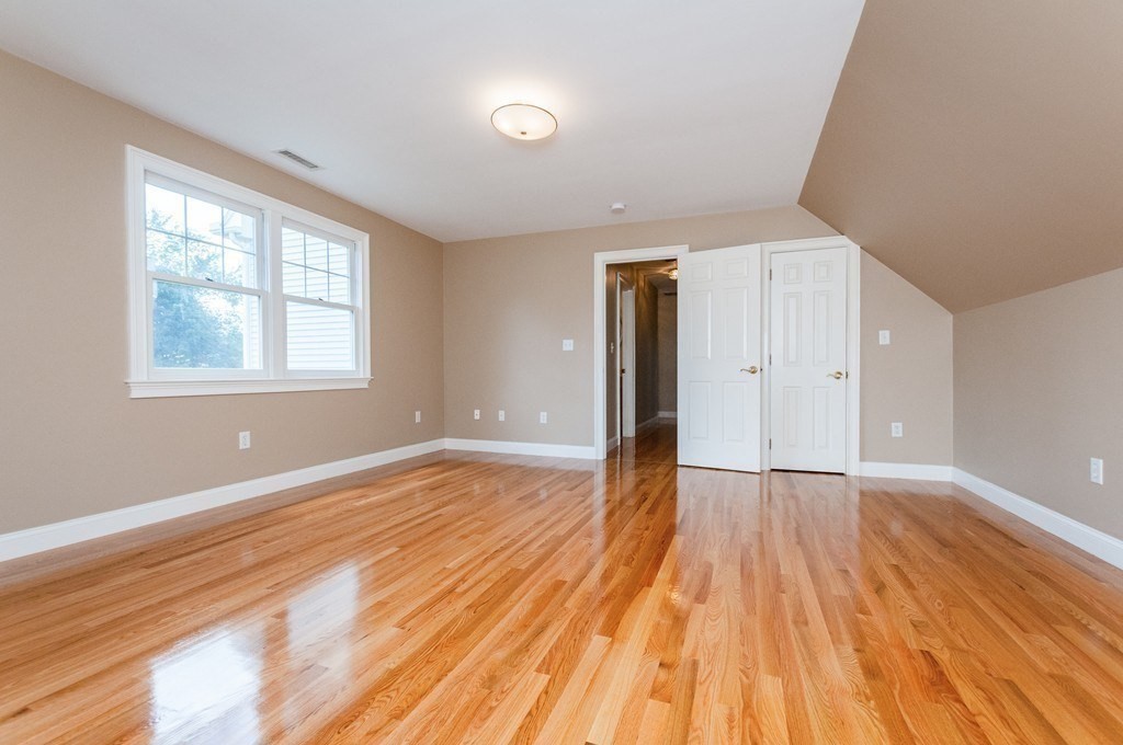 232 Pearl Street, Unit 232 Newton, MA 02458 - Photo 17 of 27 a view of an empty room with wooden floor and a window