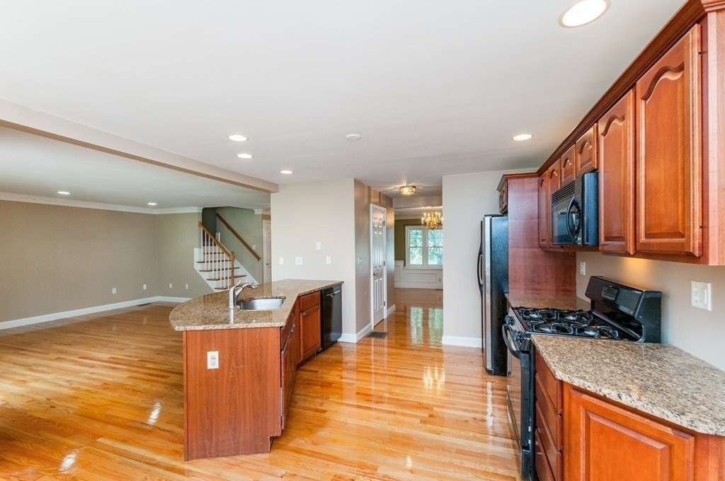 232 Pearl Street, Unit 232 Newton, MA 02458 - Photo 5 of 27 a view of a kitchen with kitchen island a counter top space a sink stainless steel appliances and cabinets