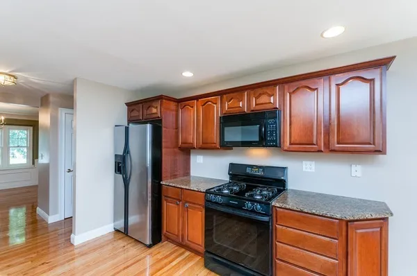 a kitchen with granite countertop stainless steel appliances and wooden cabinets