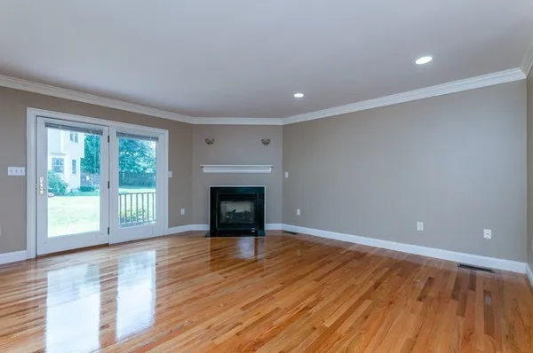 a view of empty room with wooden floor and fireplace