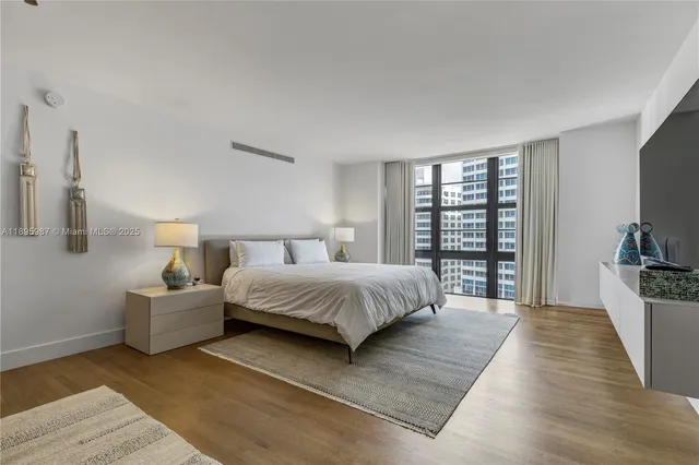 a spacious bedroom with a large bed and a large window