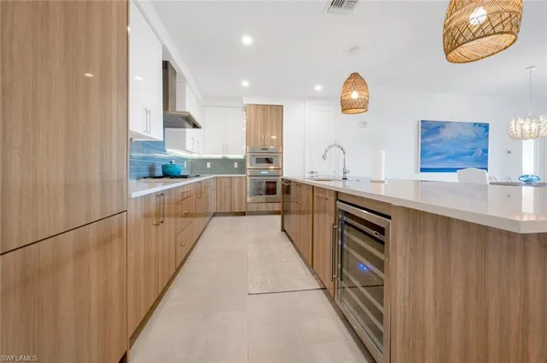 a large kitchen with stainless steel appliances granite countertop a sink and dishwasher with wooden cabinets