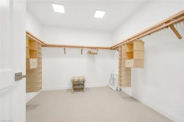a view of walk in closet with empty racks