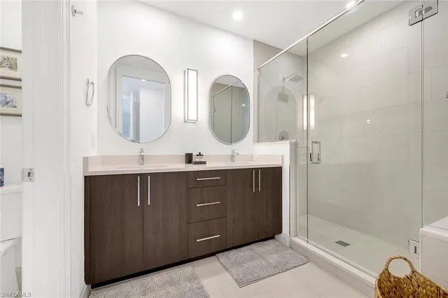 a bathroom with a double vanity sink mirror double and shower