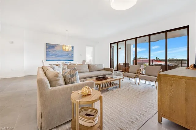 a living room with furniture and a floor to ceiling window