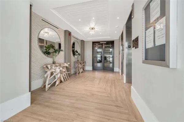 a view of a hallway with wooden floor windows and stairs