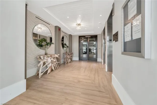 a view of a hallway with wooden floor windows and stairs