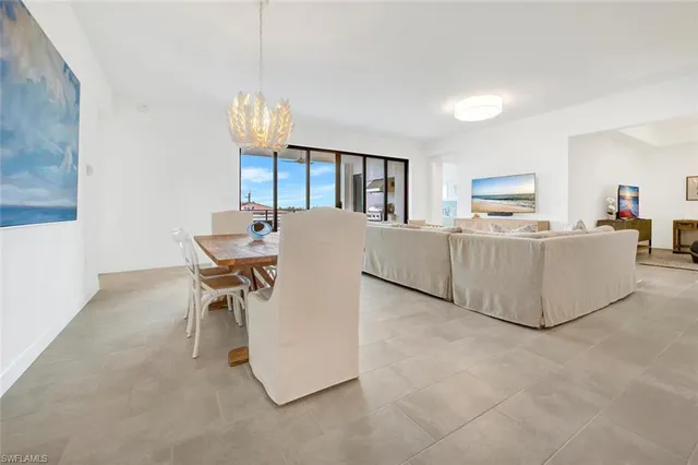 a living room with furniture a dining table and a chandelier