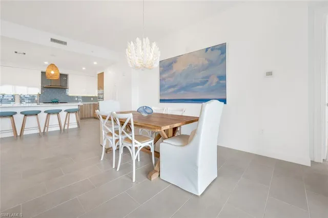 a dining room with furniture a rug and a chandelier