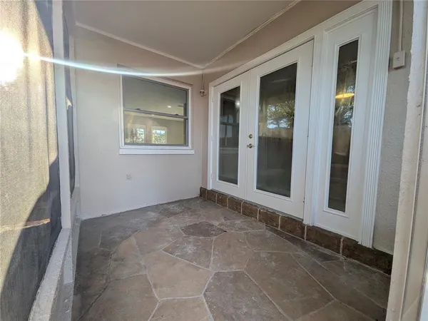 a view of an empty room with window and door