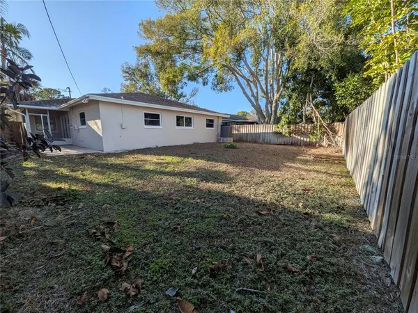 a view of a yard in front of a house with large trees