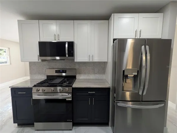 a kitchen with a refrigerator stove and microwave