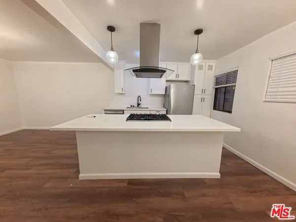 a view of a hallway with wooden floor and chandelier