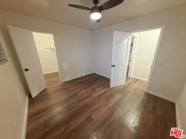 an empty room with wooden floor and staircase