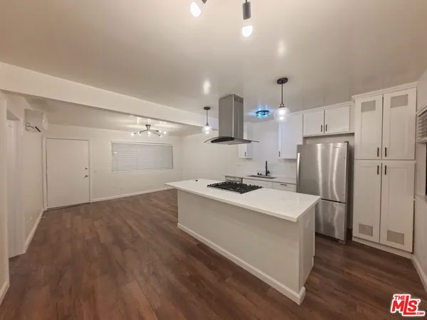 a kitchen with a sink a refrigerator and a stove top oven