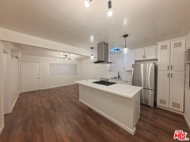a kitchen with a sink a refrigerator and a stove top oven