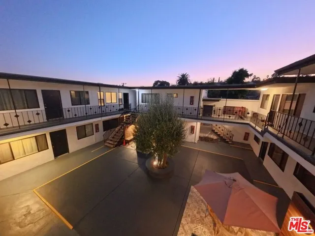 a view of a balcony with chairs and a potted plant
