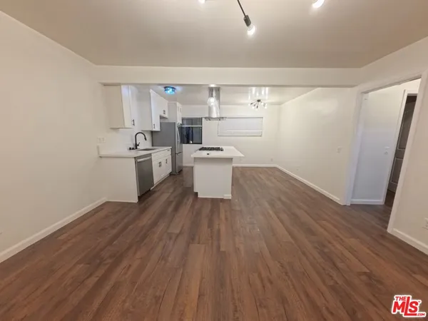 a kitchen with a sink and wooden floor